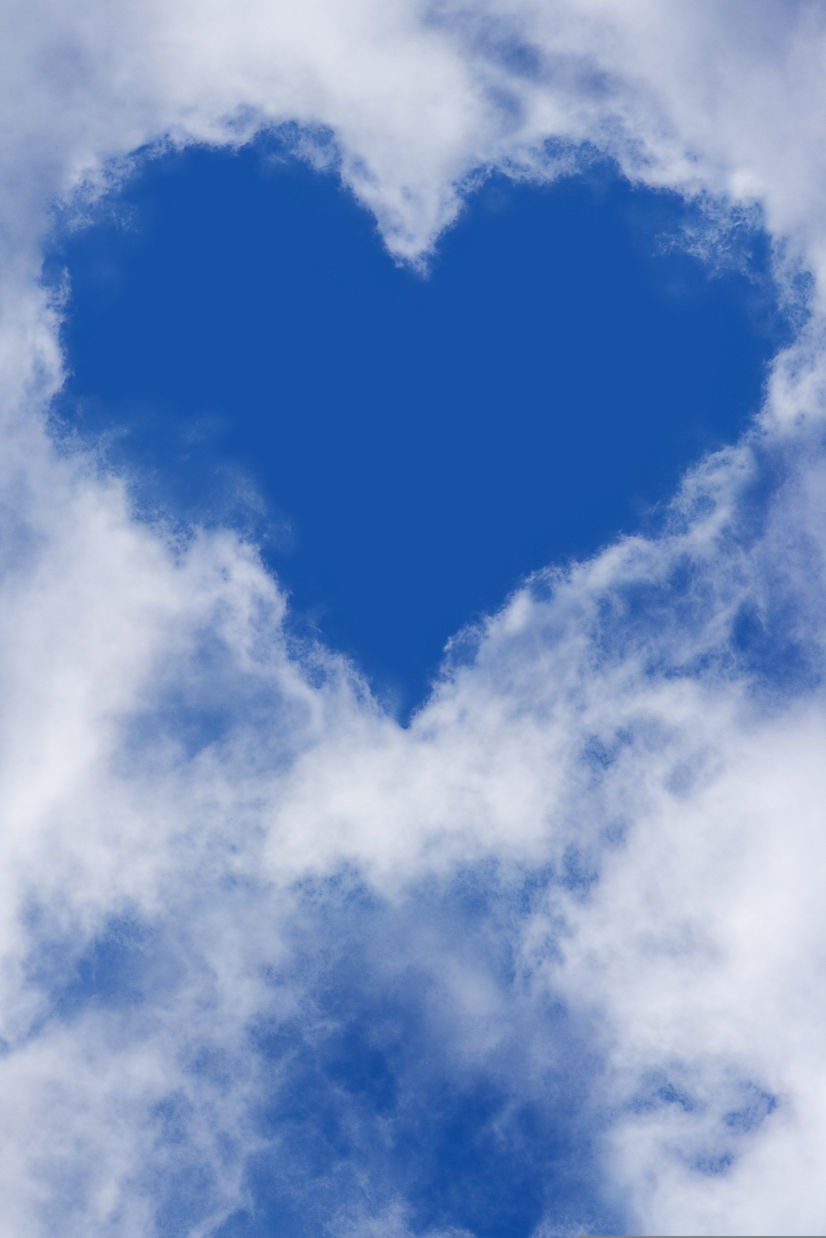 A heart shaped cloud in a blue sky